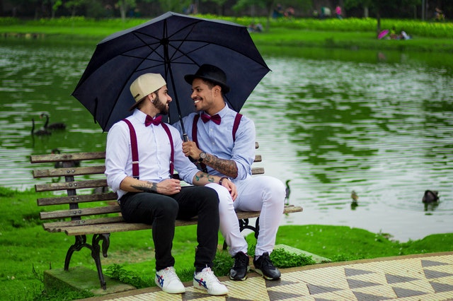 Two gay man in love sitting on a bench