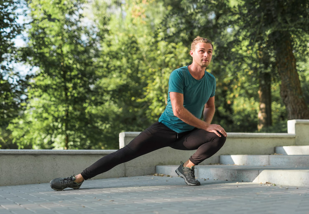 young-man-stretching-park_23-2147995927